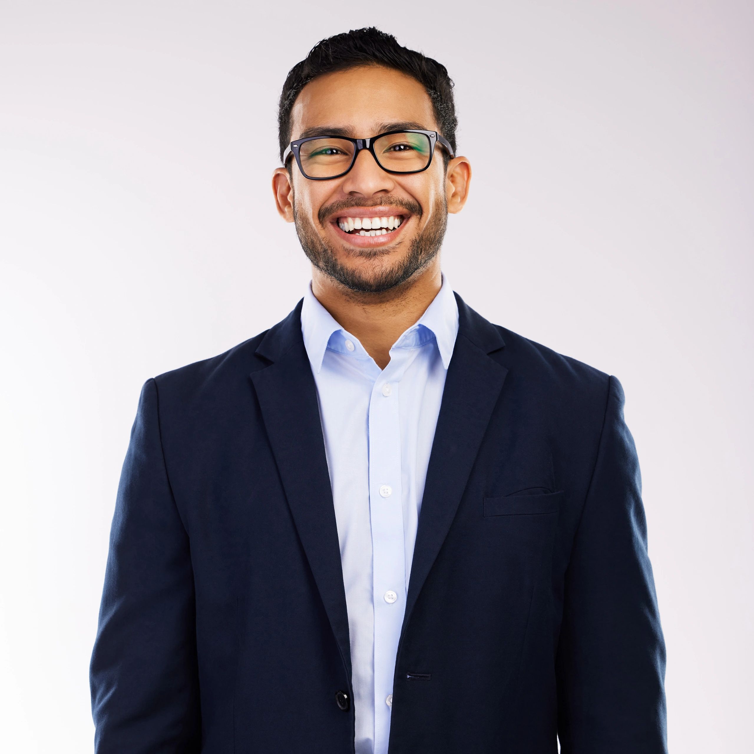 Professional headshot of a man smiling on neutral background