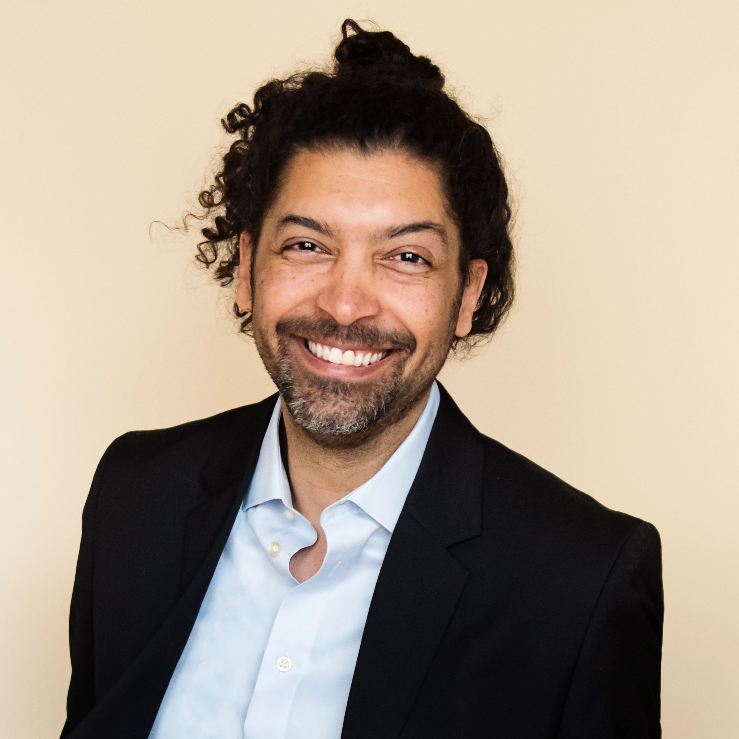 Professional headshot of a man on neutral background