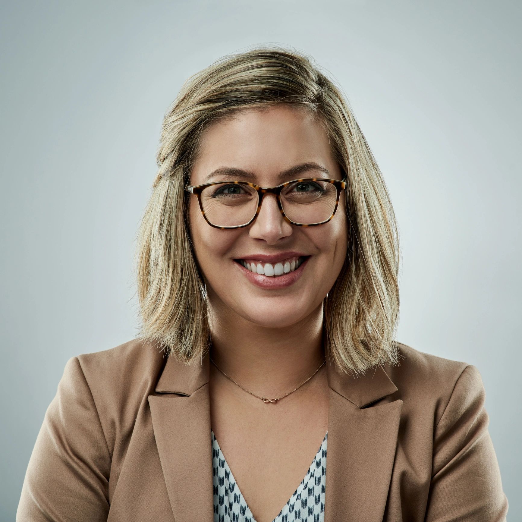 Professional headshot of a businesswoman on neutral background